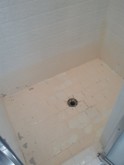 Dallas Bathtub Services removing the old paint from the tile shower pan.