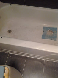 Bathtub finish worn down and chipped from age. In process of cleaning the old surface.